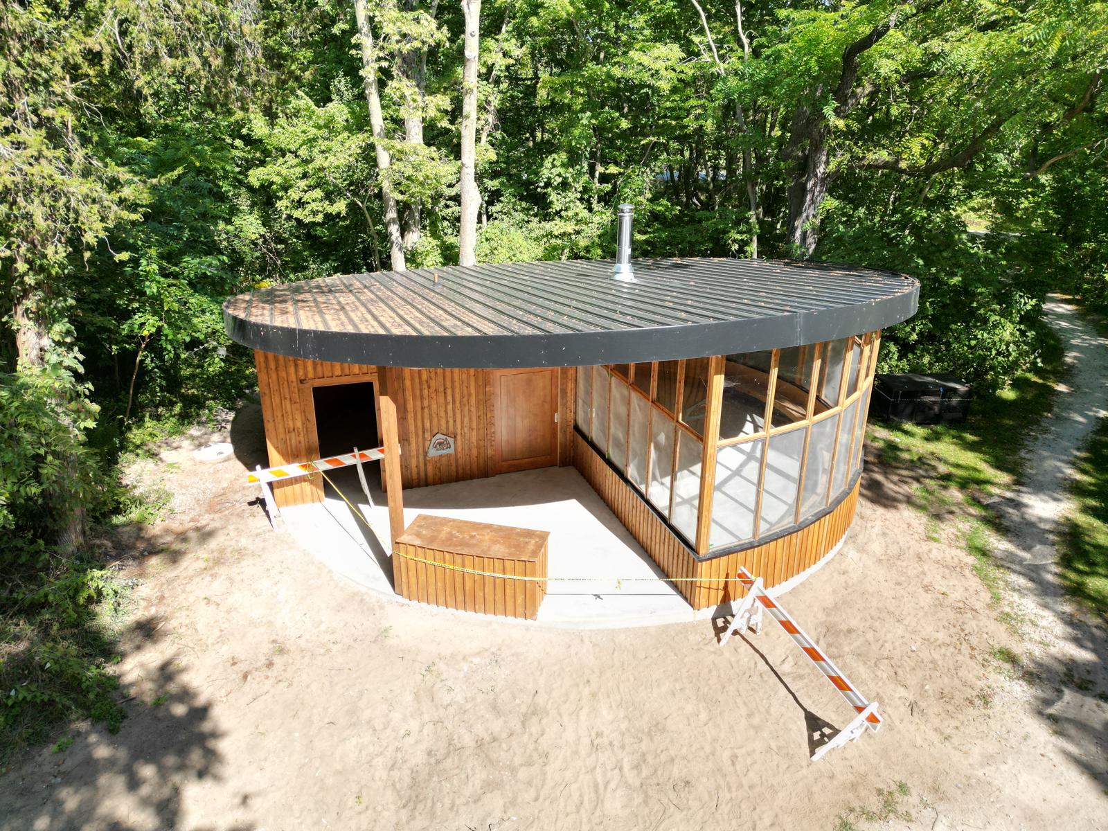 Caldwell Madbin Jina building at Point Pelee National Park, with a curved roof and glazed frontage among trees