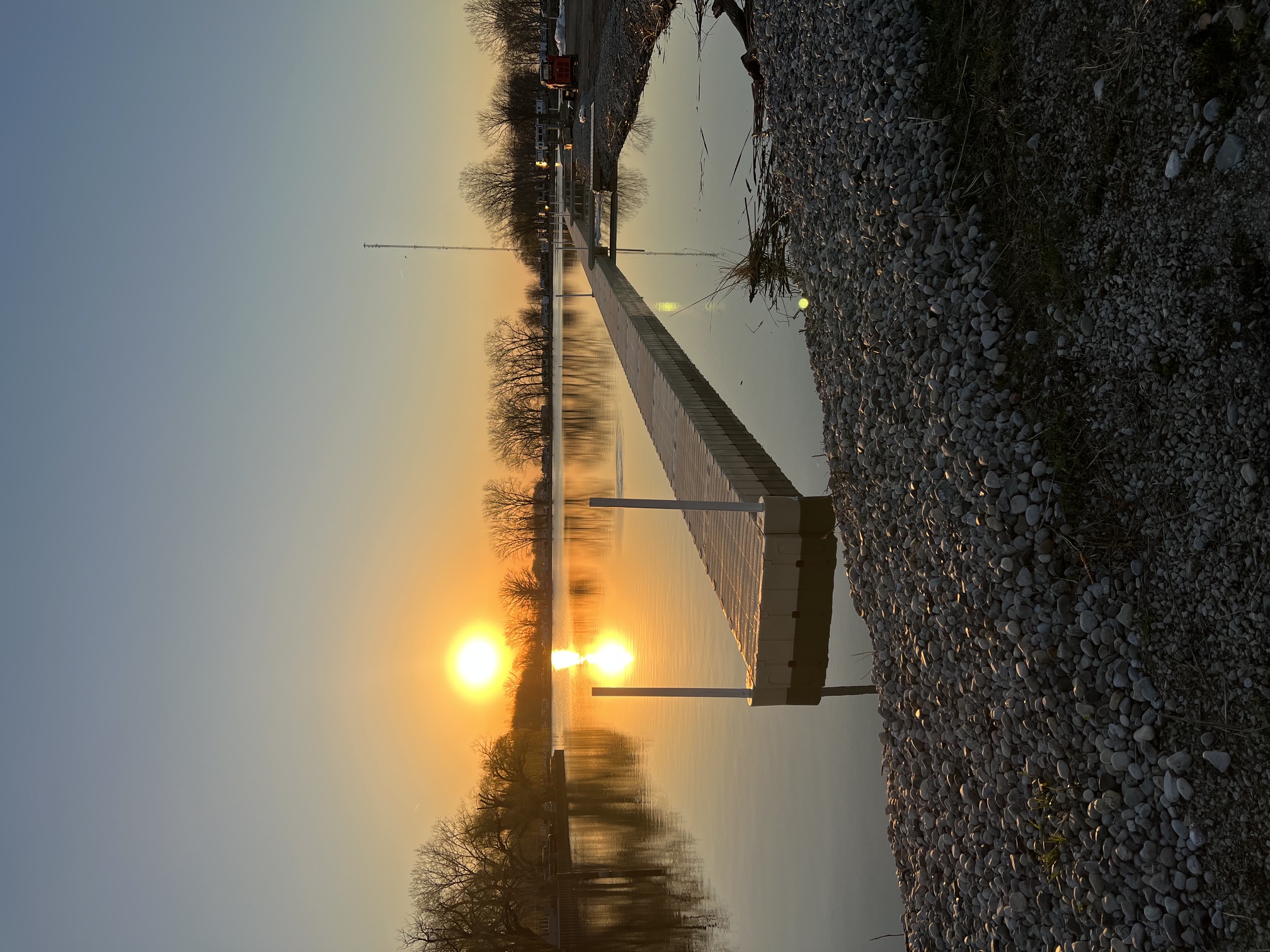 Dock at Caldwell First Nation Marina with the sunset reflected in calm water